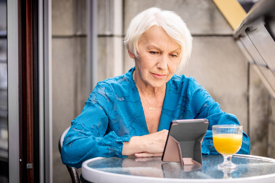 older woman reading outside on inkbook ereader